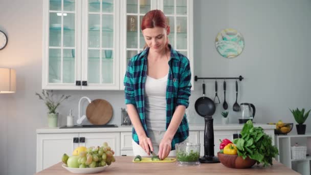 吃东西的时候 年轻女人在厨房里用搅拌机搅拌新鲜蔬菜 — 图库视频影像
