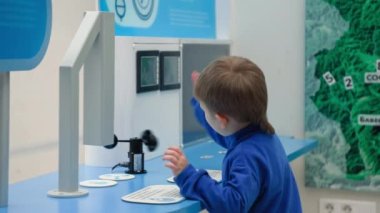 Küçük erkek çocuk, çocukların gelişimi için interaktif oyuncaklar sergisinde modern müzede eğleniyor.