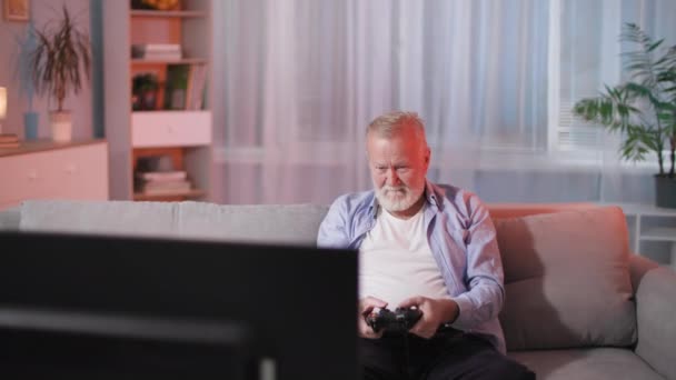 Velho Homem Joga Entusiasticamente Jogos Vídeo Alegra Vitória Levanta Mãos — Vídeo de Stock