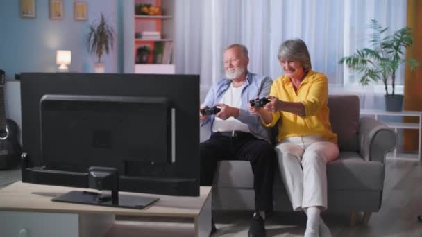 Bejaarde Echtpaar Plezier Samen Spelen Videospelletjes Console Terwijl Zitten Bank — Stockvideo