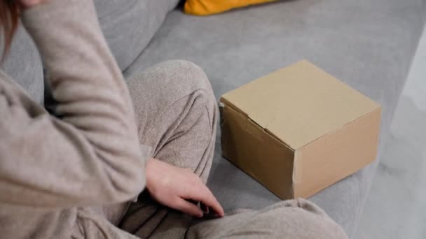 Jeune Femme Assise Sur Canapé Tenant Une Boîte Avec Cadeau — Video