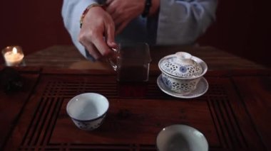 Kokulu tonik çayı hazırlamak, kimano giymiş bir kadın çay tahtasına sıcak çay döker sıcak bir odada adaletin çalılığına, yakın çekimde