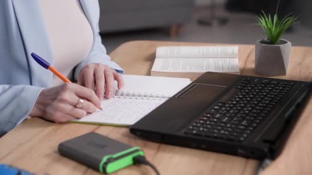 Női Irodai Dolgozó Jegyzetel Jegyzetfüzetbe Gépel Egy Laptopon Miközben Egy — Stock videók