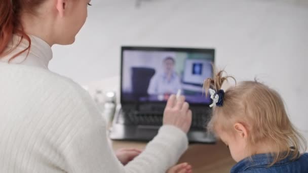 オンラインの医者の予約 病気の女性の子供を持つ母親自宅に座っている間ビデオリンクを介して医療従事者に相談 — ストック動画