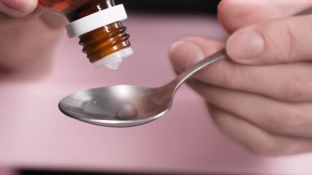 妇女手里拿着药瓶 从饮料机里滴进勺子里 这是一种安眠药 — 图库视频影像