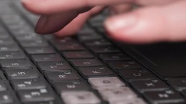 Modern teknoloji, genç kadın dizüstü bilgisayarın klavyesinde yazı yazıyor, yakın çekim.