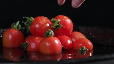 Tarım, bir kadının eli olgun sebzelerden oluşan sulu bir domatesi alır, yakın plan.