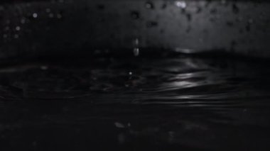 Hasat, sulu domatesler, koyu bir kase su sıçratarak servis edilir. Yan tarafa uç, yakın plan ayrıl.