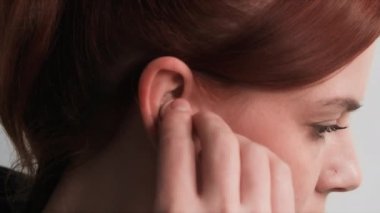 Modern teknoloji, genç bir kadın müzik dinlemek için kulaklığa kablosuz kulaklık takıyor.