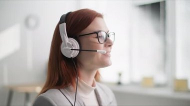 Teknik destek, genç bir kadın çağrı merkezi operatörü bir kafede otururken mikrofonla bir müşteriyle konuşuyor.