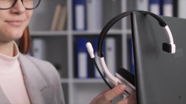 Modern teknoloji, mutlu çalışan ofiste çağrı merkezi operatörü olarak çalışırken müşterilerle iletişim kurmak için kulaklık takıyor.