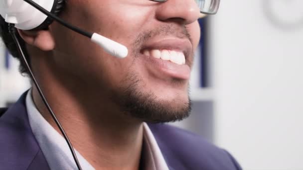 年轻的非洲裔美国人呼叫中心员工在办公室里用耳机与客户交谈 — 图库视频影像