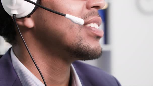 コールセンターの仕事 友好的な若いアフリカ系アメリカ人の男オフィスに座っている顧客にガーニッシュと話す クローズアップ — ストック動画