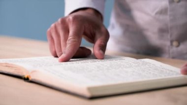 Din ve meditasyon, genç Afro-Amerikan adam odada diz çökerken İncil okuyor, kapat.