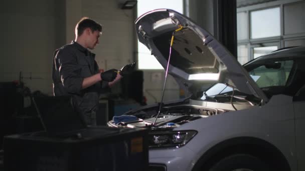 Manutenção Carro Trabalhador Masculino Profissional Verifica Óleo Motor Plataforma Técnica — Vídeo de Stock