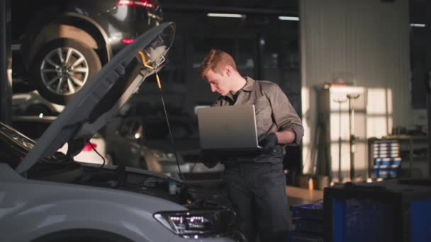 Service Station Professional Male Mechanic Uniform Works Laptop Checks Technical — Stock Video