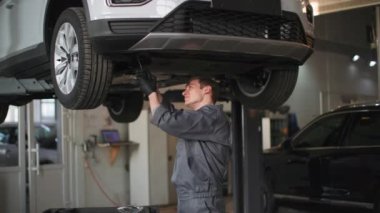 Otomobil servisi, profesyonel tamirat aletleri bir otomobil merkezinde hidrolik rampada bir araba tekerleği.
