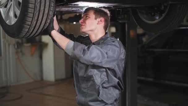 Portrét Mladého Automechanika Klíčem Ruce Který Kontroluje Auto Hydraulické Rampě — Stock video