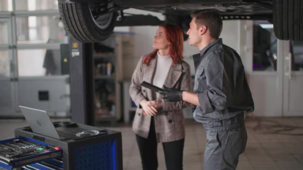 Kobieta Wraz Mężczyzną Mechanik Samochodowy Kontroli Pojazdów Mechanicznych Rampie Hydraulicznej — Wideo stockowe