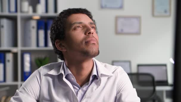 Retrato Del Joven Médico Negro Poniéndose Fonendoscopio Mientras Está Sentado — Vídeos de Stock