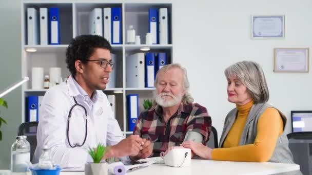 Betegek Fogadása Egy Idős Házaspár Konzultál Egészségi Állapotról Fiatal Hivatásos — Stock videók