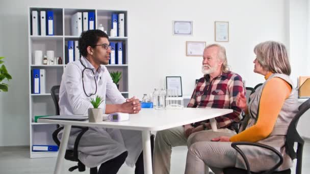 Svart Manlig Läkare Som Talar Med Äldre Man Och Kvinna — Stockvideo