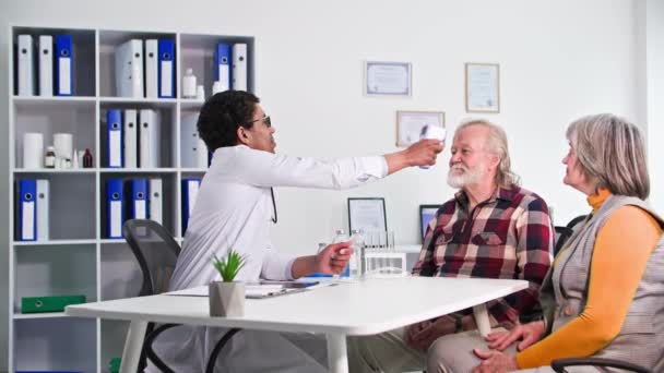 Медицинское Обслуживание Черный Мужчина Врач Измеряет Температуру Пожилого Пациента Время — стоковое видео