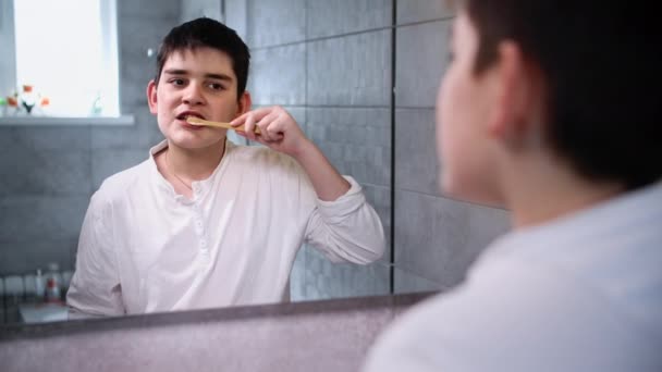 迷人的青少年注意口腔卫生 在浴室用牙膏和刷子刷牙 照镜子 — 图库视频影像