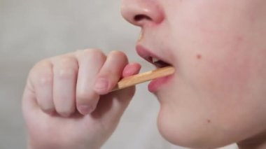 Erkek çocuk diş macunu ve bambu gagasıyla dişlerini fırçalıyor.