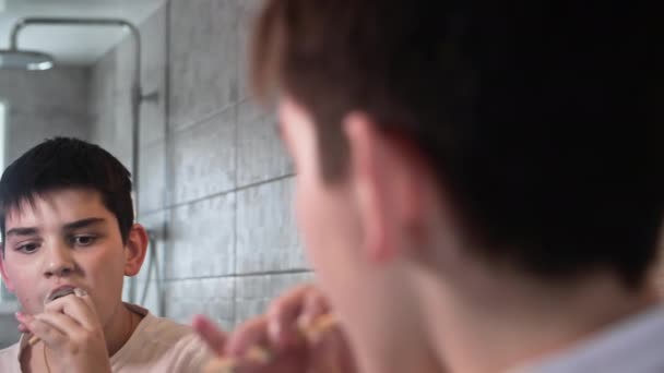 歯ブラシで歯磨きを施した男の子の肖像画とトイレで鏡を見たペースト クローズアップ — ストック動画