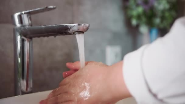在医疗保健方面 一名男婴在洗脸盆里用自来水洗手并冲洗干净 — 图库视频影像