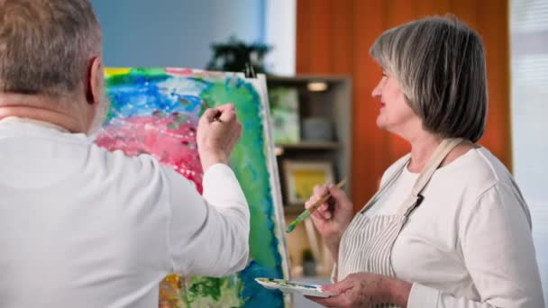 은퇴한 예술가 여성과 남성은 집에서 페인트와 브러시를 사용하여 창조적 그림을 — 비디오