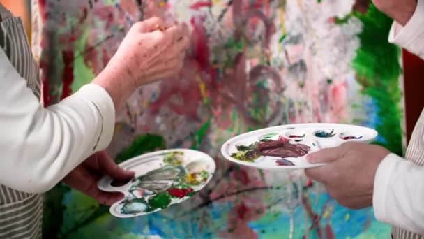 退休生活中的创造力 快乐的老夫妇在画架上欢快地画着现代的图画和画笔 特写着 — 图库视频影像