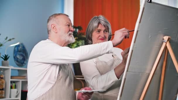 笑顔の女性と夫は自宅でキャンバスに筆や絵を描いています — ストック動画