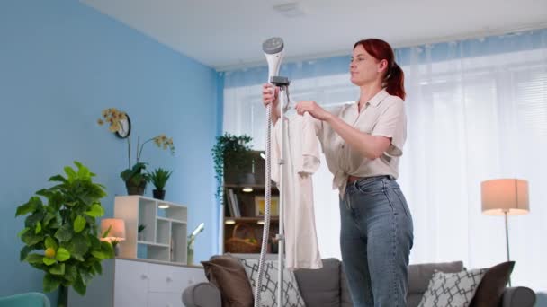 Hausaufgaben Junge Frau Mit Moderner Dampfgarderobe Auf Kleiderbügel Hause — Stockvideo
