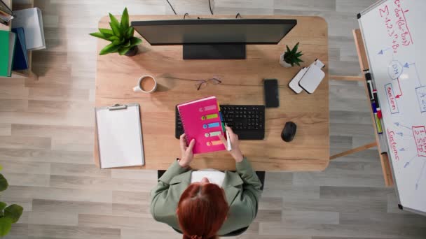 オフィスのコンピュータに座っている若い女性マネージャーは キーボードを入力し オフィス勤務時間中に日記を記入します トップビュー — ストック動画
