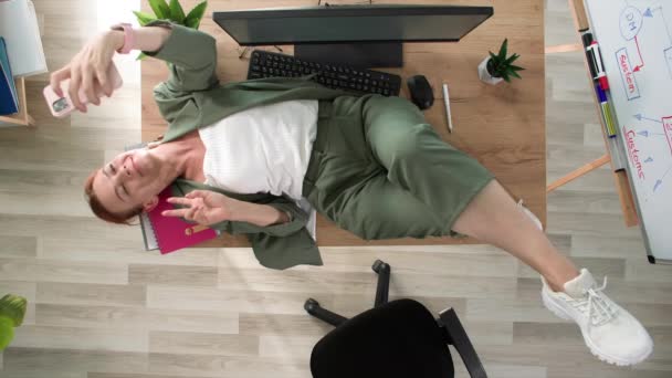 Sorrindo Mulher Tomando Selfie Enquanto Deitado Mesa Durante Pausa Para — Vídeo de Stock