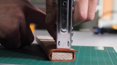 Craft, zımba kullanan adam masaya tahta yumruklar, yakın plan.