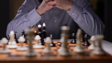 Strateji planlama, başarılı erkek işadamı satranç oynuyor ve bir sonraki hamleyi yakın plan yapmayı düşünüyor.