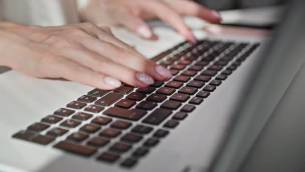 女性手在笔记本电脑键盘上打字 坐在桌旁 — 图库视频影像