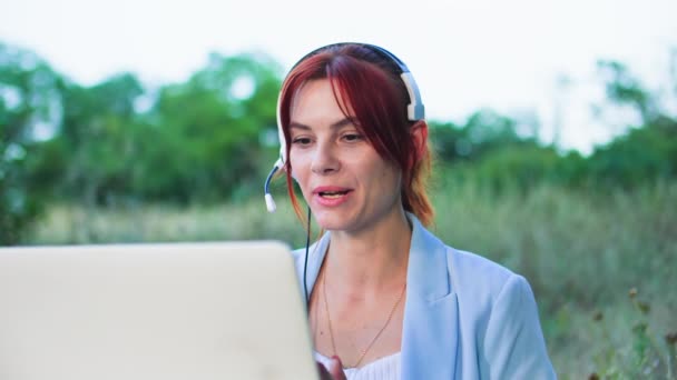 Mosolygó Beszél Videohívás Segítségével Fejhallgató Mikrofonnal Laptoppal Miközben Parkban Háttér — Stock videók