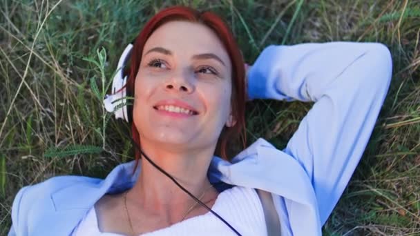 Serbest Çağrı Merkezi Kulaklıklı Gülümseyen Kadın Parkta Çimenlerde Uzanan Müşteriyle — Stok video