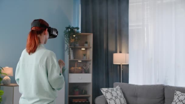 现代技术 一个戴着Viar眼镜的年轻女性通过虚拟交流与一个舒适房间里的同事交流 — 图库视频影像
