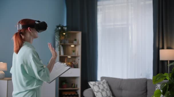 虚拟现实中 一个戴着玻璃杯的年轻女人在一个舒适的房间里与老板交流 — 图库视频影像