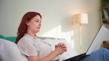 Uzaklık iletişimi, evdeki kanepede dinlenirken bilgisayardaki arkadaşlarıyla görüntülü konuşma.