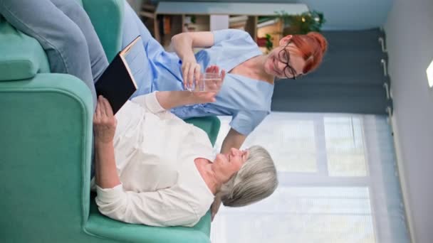 Nursing Home Young Woman Medical Uniform Takes Care Elderly Woman — Stock Video