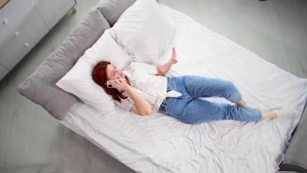 Bekymmerslös Ung Kvinna Att Kul Prata Mobiltelefon När Ligger Sängen — Stockvideo