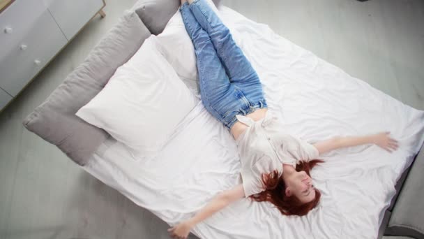 Безтурботний Молода Жінка Мрійливо Лежить Ліжку Простягнутими Руками Розслабляючись Вдома — стокове відео