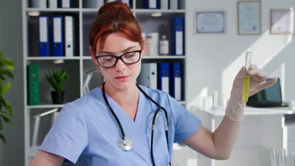 手袋の女性看護師は 反応のための試薬を検査し 医療オフィスに座っている間コンピュータに観察を書き込みます — ストック動画