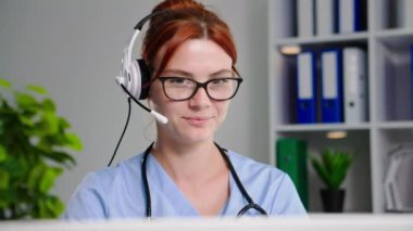 Modern tıbbi danışmanlık, genç bir doktor hastane ofisinde otururken hastayla video bağlantısı üzerinden iletişim kuruyor.